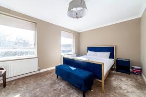 a bedroom with a bed and a blue stool at Wonderful 5 BDR Flat wParking, Maida Vale in London