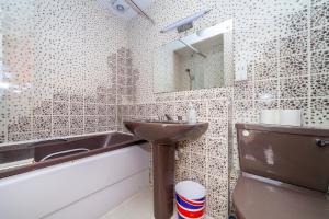 a bathroom with a sink and a mirror and a tub at Wonderful 5 BDR Flat wParking, Maida Vale in London