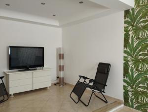 a living room with two chairs and a flat screen tv at Villa Madreselva in Cinisi