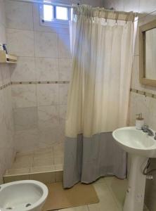 La salle de bains est pourvue d'un rideau de douche et d'un lavabo. dans l'établissement Apartamento Entero en Ezeiza/ Canning, à Canning