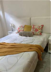 - un lit avec 2 oreillers et une couverture dans l'établissement Apartamento Entero en Ezeiza/ Canning, à Canning