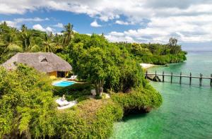 une île dans l'eau avec une maison et une piscine dans l'établissement Zanzi Resort, à Zanzibar City