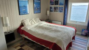 a bedroom with a bed with a view of the ocean at Solodden, Authentic rorbu in Lofoten in Sennesvik