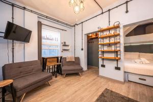 a room with a bed and a table and chairs at Pass the Keys London Industrial studio flat Harry Potter Theme in London