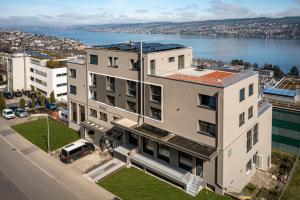 an apartment building with a view of a body of water at aestate living lakeview in Horgen Zürich Zug Pfäffikon in Horgen