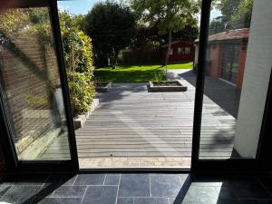 una porta aperta su un portico con patio di Villa avec jardin a Saint-Cloud