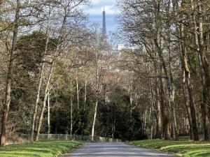 eine Straße mit dem Eiffelturm im Hintergrund in der Unterkunft Villa avec jardin in Saint-Cloud