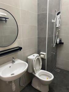 a bathroom with a sink and a toilet and a mirror at Cloud Nine Homestay in Taiping +34 photos