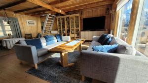 a living room with two couches and a wooden table at Solodden, Authentic rorbu in Lofoten in Sennesvik