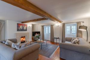 a living room with two couches and a fireplace at Cotswold Cottage in Cirencester