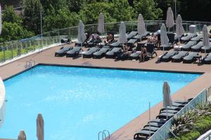 a swimming pool with chaise lounge chairs and people sitting at Ailenizle keyifle kalabileceğiniz eşsiz bir daire in Istanbul
