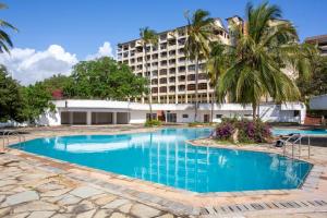 a large swimming pool in front of a hotel at Imani Front Beach Appartment in Diani Beach