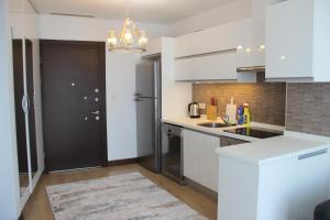 a kitchen with white cabinets and a black door at Ailenizle keyifle kalabileceğiniz eşsiz bir daire in Istanbul