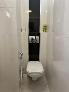 a white bathroom with a toilet and a shower at Imani Front Beach Appartment in Diani Beach +8 photos