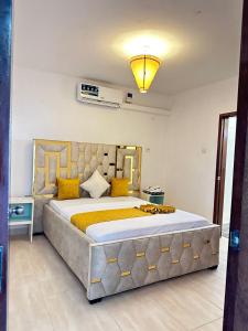 a bedroom with a large bed with yellow pillows at Imani Front Beach Appartment in Diani Beach +8 photos