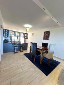 a living room with a wooden table and chairs at Imani Front Beach Appartment in Diani Beach