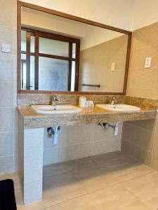 a bathroom with two sinks and a large mirror at Imani Front Beach Appartment in Diani Beach
