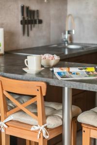 a kitchen counter with a table with a cup on it at Unique Apartment KAMPAT with Balcony for 4 Guests by Renters in Świnoujście