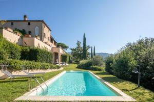 a swimming pool in a garden with a house at Villa Belforte by VacaVilla in Lamporecchio