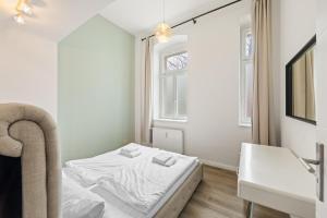 a small bedroom with a bed and a sink at primeflats - Apartment Langhans Berlin-Weißensee in Berlin