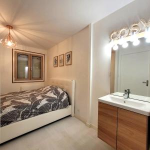La salle de bains est pourvue d'un lit, d'un lavabo et d'un miroir. dans l'établissement La perle d'Eybens, à Eybens