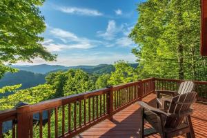 a deck with two chairs and a view of the mountains at The Skybox Cabin Stunning Views HotTub Game Room in Swiss