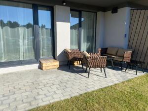 a patio with chairs and a couch and windows at Laiminga banga in Palanga