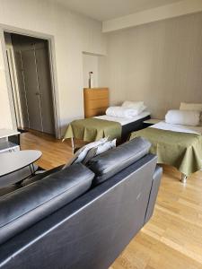 Habitación de hotel con 2 camas y sofá en Live and Stay Lagerbring en Gotemburgo