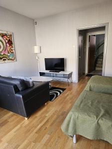 a living room with a black couch and a tv at Live and Stay Lagerbring in Gothenburg