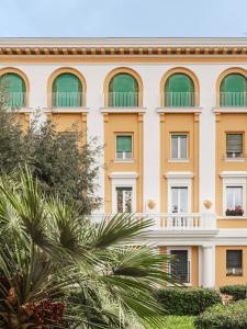 um edifício com janelas verdes e uma palmeira em Maison boutique Matteotti em Matera