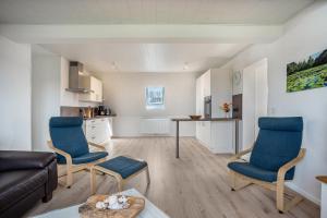 a living room with blue chairs and a couch at 5 Sterne Ferienwohnung Boddenblick in Glowe