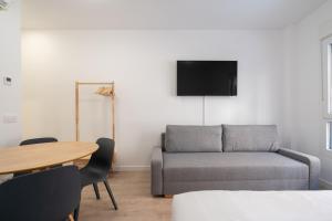 een woonkamer met een bank en een tafel bij apartamentos en vallecas in Madrid