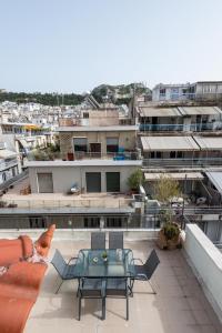 a patio with a table and chairs on top of a building at zen penthouse in exarchia in Athens