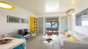 Una sala de estar con un sofá blanco y una mesa. en Villa Sand and Sea, en Pelekas