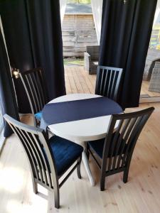 a white table with two chairs and a blue seat at Patio Dębki in Dębki