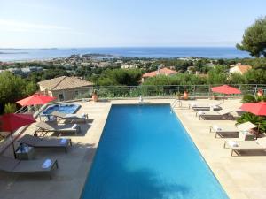 a swimming pool with lounge chairs and umbrellas at Villa Azur Golf in Bandol