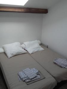 a bed with two towels on top of it at Bienvenus à Thèse - Appartement Bleu in Marseille