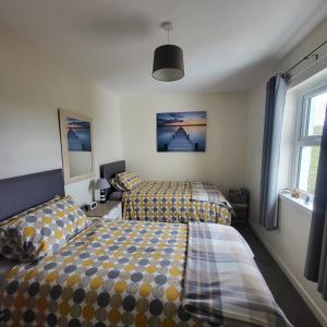 a bedroom with two beds and a window at RAWSON COTTAGE LOVELY 2 BEDROOM SEMI RURAL in Stranraer +17 photos