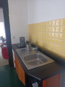 a bathroom with a sink and yellow tile on the wall at farbenfrohe,ruhige Ferienwohnung in Groß Haßlow