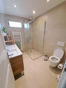 une salle de bains avec douche, toilettes et lavabo dans l'établissement L'écureuil parisien Maison de charme avec jardin proche Paris, à Cormeilles-en-Parisis 23 autres photos