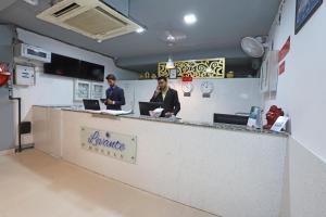 deux hommes assis à un comptoir avec leurs ordinateurs portables dans l'établissement Super Capital O Hotel Levanti Near Aravali Biodiversity Park, à Gurgaon