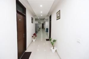 un couloir avec deux plantes en pot dans un bâtiment dans l'établissement Super Capital O Hotel Levanti Near Aravali Biodiversity Park, à Gurgaon