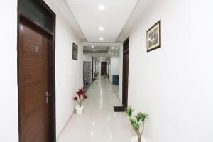 un pasillo de oficina con un pasillo con una puerta y plantas en Super Capital O Hotel Levanti Near Aravali Biodiversity Park, en Gurgaon