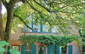 a brick house with blue doors and a tree at Stunning Apartment In Rheinsberg Ot Linow With Kitchen in Linow