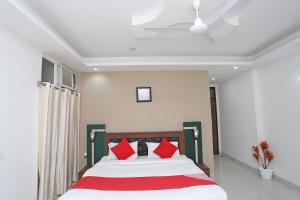 a bedroom with a large bed with red pillows at Super Capital O Levanti Near Aravali Biodiversity Park in Gurgaon