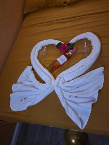 Rose Hideaway في فيو فورت: منشفة على شكل قلب مع زجاجة على سرير