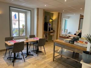 a room with a table and chairs and a counter at Hôtel Le Bayeux in Bayeux