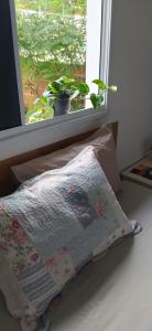 uma almofada sentada numa cama em frente a uma janela em Suíte completa em condomínio fechado em Petrolina