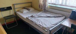 a small bed in a room with a window at Basildon House in Basildon