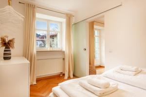 Un dormitorio blanco con dos camas y una ventana. en Best Butler Apartments Golden Glory I Zentrum I Küche I Parken I Netflix, en Füssen